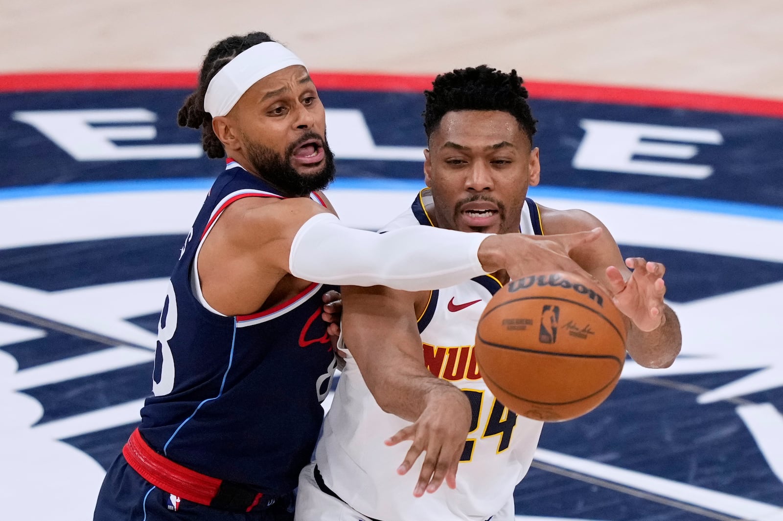 Los Angeles Clippers guard Patty Mills, left, and Denver Nuggets guard Jalen Pickett reach for a loose ball during the second half in Game 3 of an NBA basketball first-round playoff series Thursday, April 24, 2025, in Inglewood, Calif. (AP Photo/Mark J. Terrill)