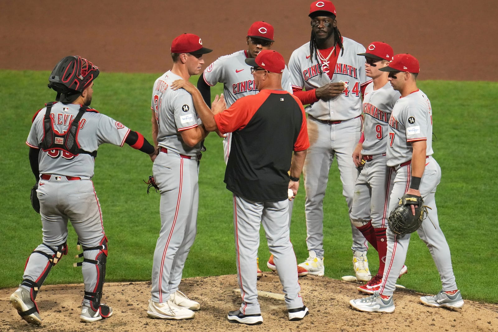 Cincinnati Reds pitcher Brent Suter, second from left, listens to manager Terry Francona, front center, after handing Francona the ball during the seventh inning of a baseball game against the Pittsburgh Pirates in Pittsburgh, Thursday, Aug. 7, 2025. (AP Photo/Gene J. Puskar)
