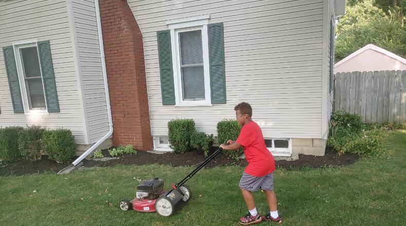 Adian Harris, 9, mows a lawn over the summer as part of a challenge he took on to mow 50 lawns for the elderly, disabled, single parents or veterans. Courtesy of Ron Robert.