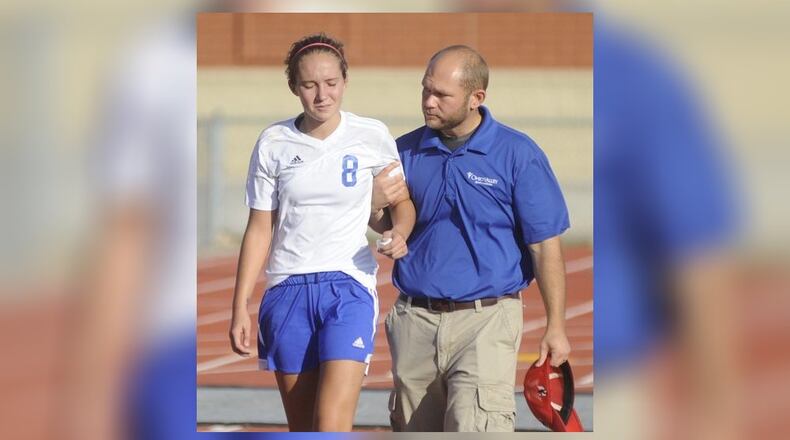 In this 2014 file photo, Northwestern’s Mogan Crawford is escorted off the field after sustaining an injury. MARC PENDLETON/STAFF/FILE