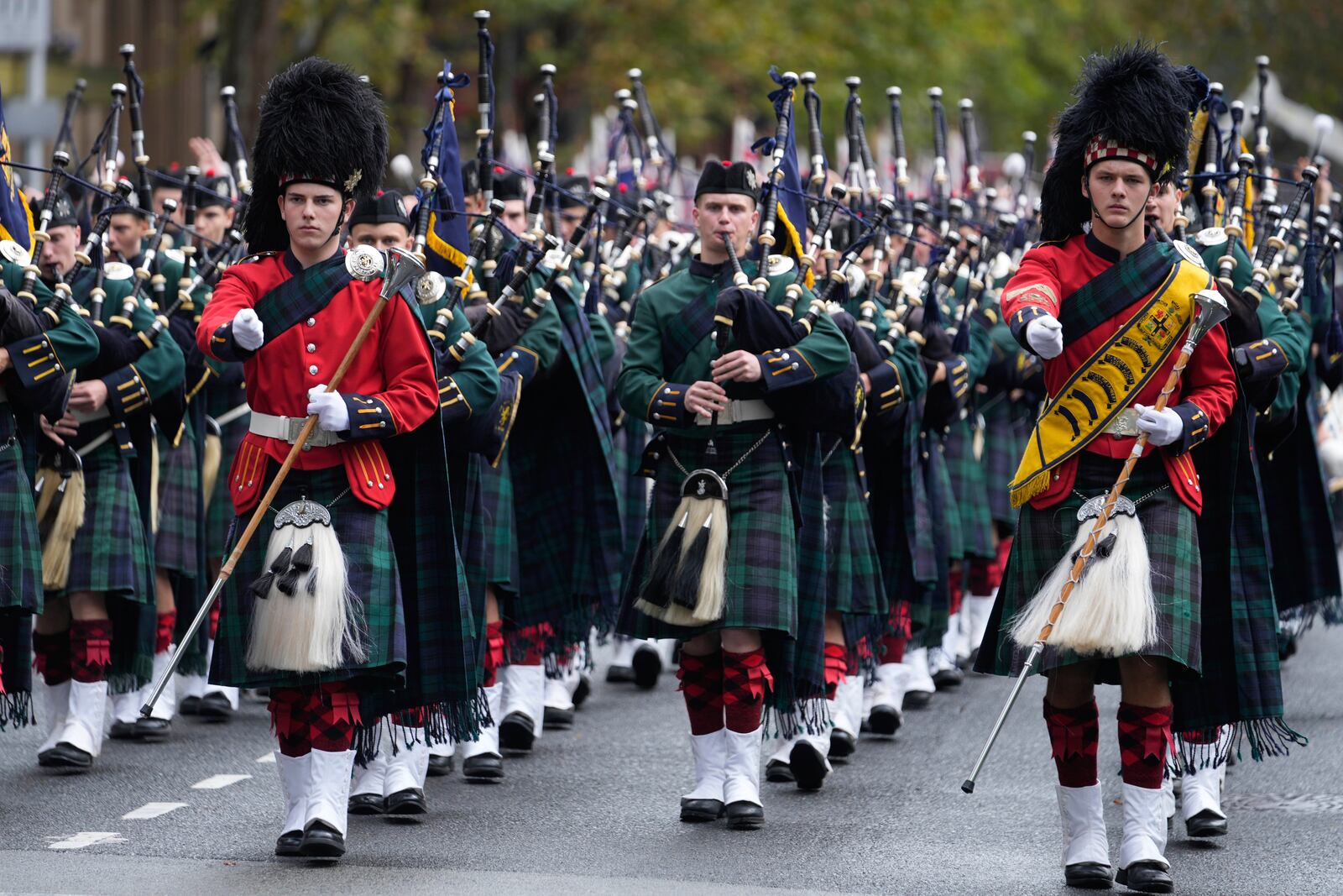 A pipe band marches past thousands of people lining the street to pay tribute to their war dead during the Anzac Day parade in Sydney, Australia, Friday, April 25, 2025. (AP Photo/Rick Rycroft)