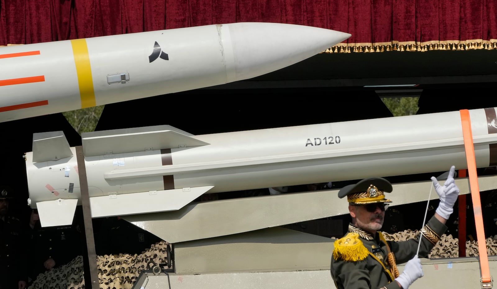 FILE - Missiles are carried on a truck as an Iranian army band leader conducts the music band during Army Day parade at a military base in northern Tehran, Iran, Wednesday, April 17, 2024. (AP Photo/Vahid Salemi, File)