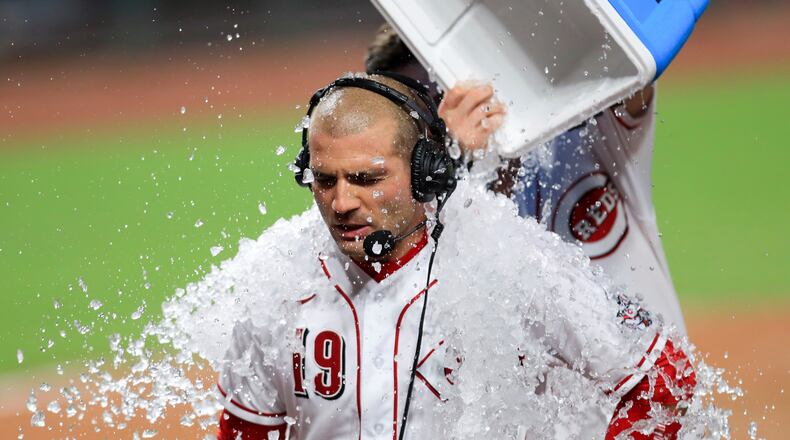 Cincinnati Reds' Joey Votto, front, is doused by water and ice by teammate Jesse Winker, back, after hitting an RBI walk-off single in a baseball game against the St. Louis Cardinals in Cincinnati, Wednesday, Sep. 2, 2020. The Reds won 4-3. (AP Photo/Aaron Doster)