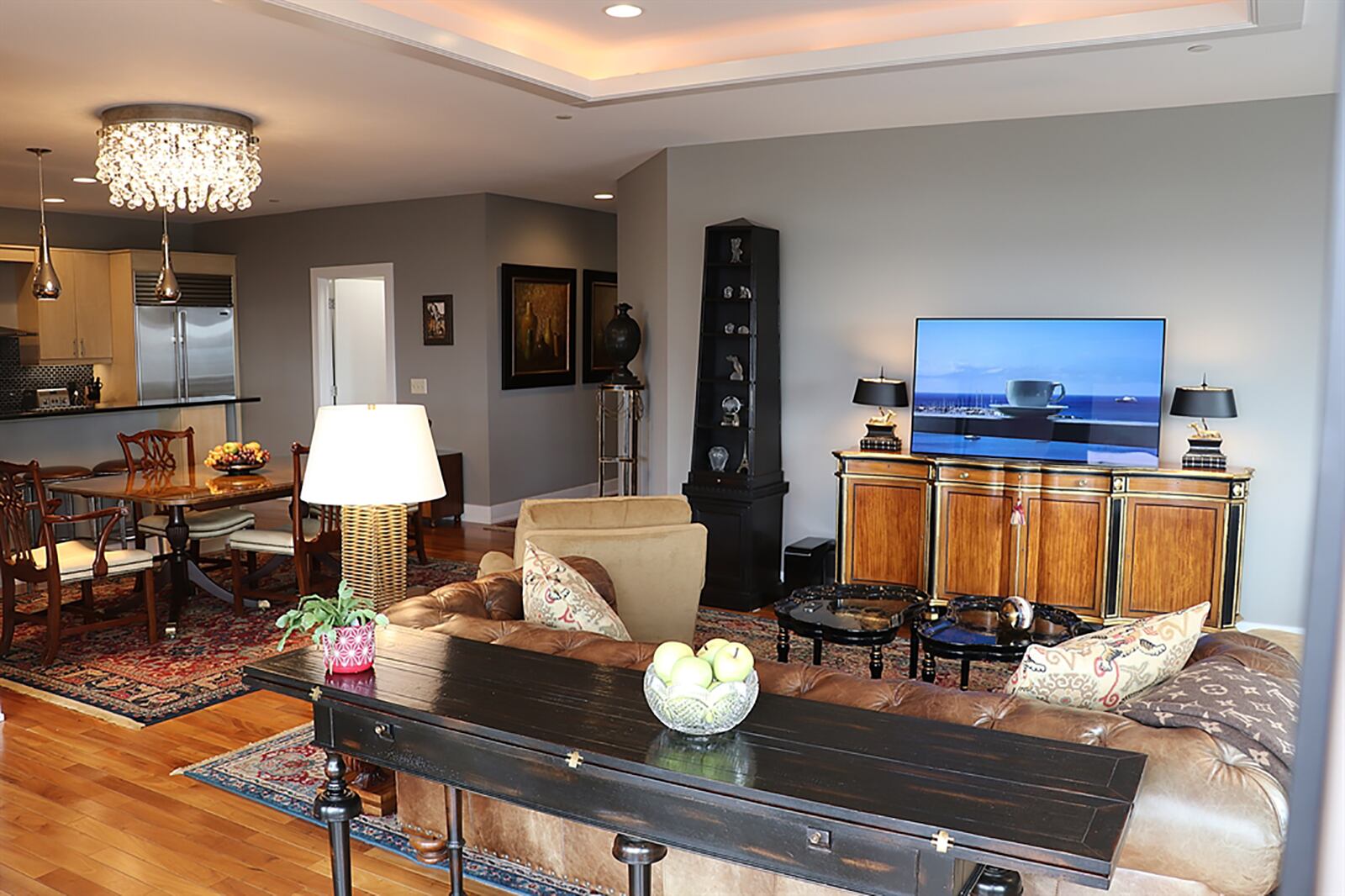 A tray ceiling has accent lighting and is above the living room.  A crystal light fixture with dimmer is above the dining area. CONTRIBUTED PHOTO BY KATHY TYLER