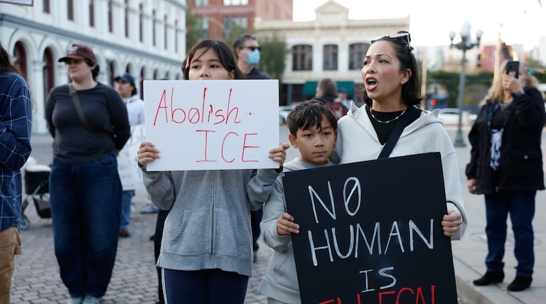 Demonstrators hold signs during a protest in response to the fatal shooting of 37-year-old Alex Pretti in Minneapolis earlier in the day Saturday, Jan. 24, 2026, in Los Angeles. (AP Photo/Caroline Brehman)