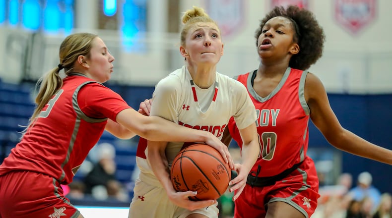 Stebbins High School junior Miley Amann drives through Troy's Claire Meredith and Simone Adekoya during a Division II district semifinal game on Monday night at Fairborn High School. MICHAEL COOPER/CONTRIBUTED