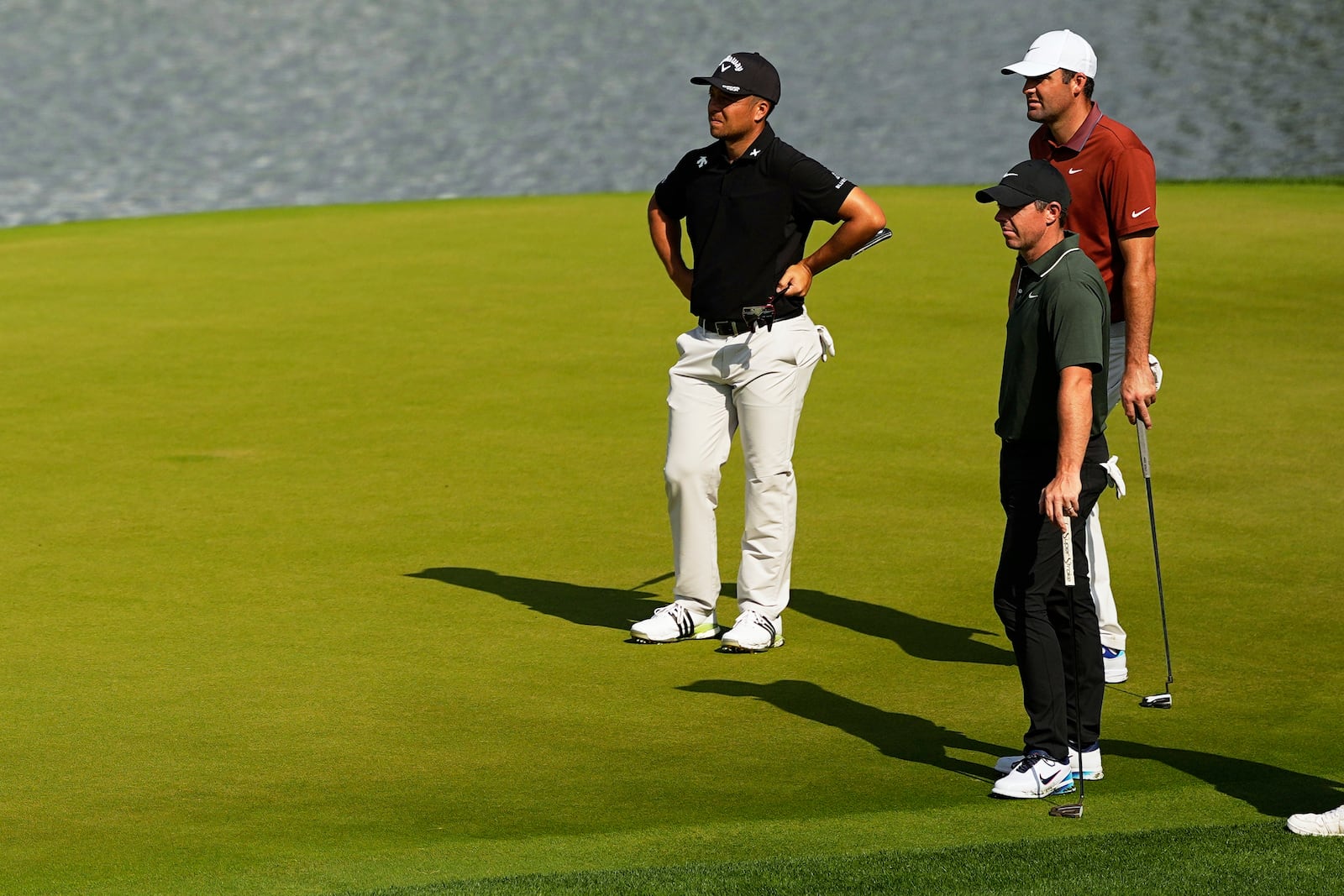 Xander Schauffele, Rory McIlroy, of Northern Ireland, and Scottie Scheffler line up a their putts on the 14th hole during the first round of the PGA Championship golf tournament at the Quail Hollow Club, Thursday, May 15, 2025, in Charlotte, N.C. (AP Photo/David J. Phillip)