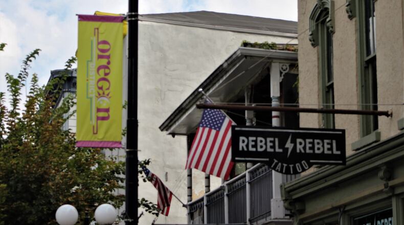 An Oregon District banner hangs from a pole along East Fifth Street. Downtown may get some new signage. CORNELIUS FROLIK / STAFF