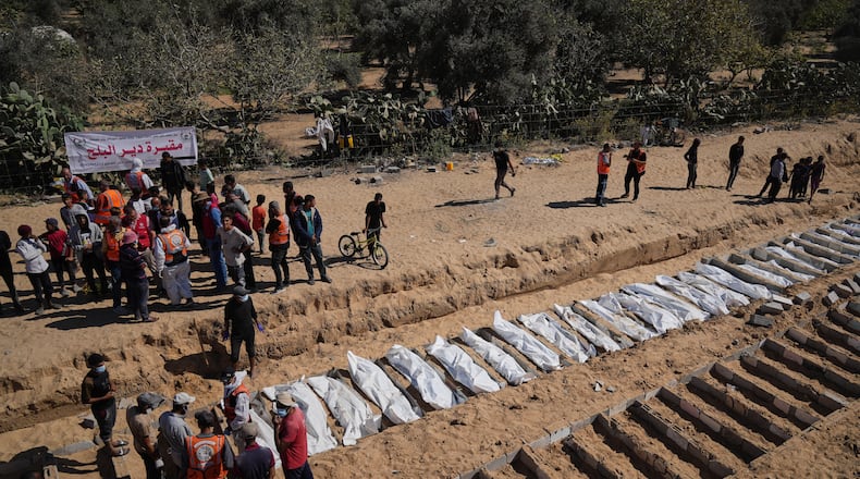 Bodies of unidentified Palestinians returned from Israel are buried in a mass grave in Deir al-Balah, Gaza Strip, Monday, Oct. 27, 2025. (AP Photo/Jehad Alshrafi)