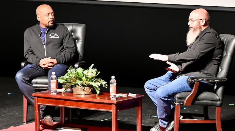 Pinball Garage owner Brad Baker asks entrepreneur Daymond John, who is one of the investors on the television show Shark Tank, Thursday evening, Nov. 14, 2025, on the Parrish Auditorium stage at Miami University Hamilton. The interview and discussion was part of the Harry T. Wilks Distinguished Lecture Series. John, known as "The People's Shark," invested in Baker's VPcabs Virtual Pinball business in 2016, which he has since sold. MICHAEL D. PITMAN/STAFF