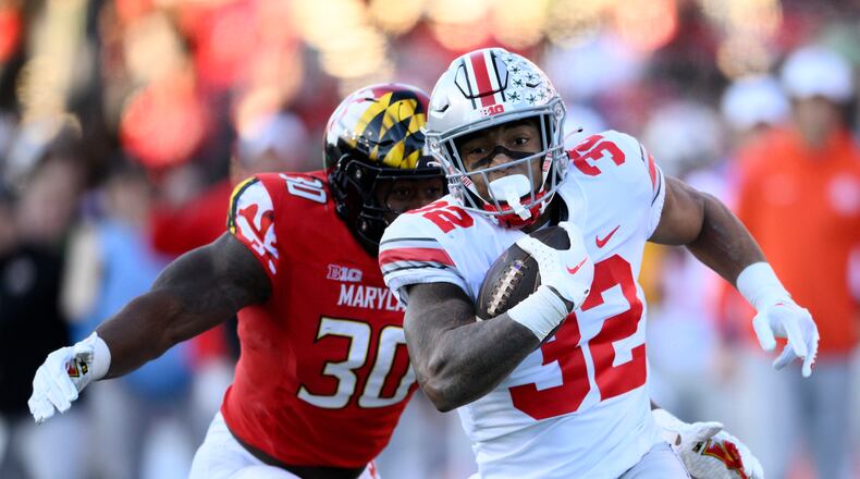 Ohio State running back TreVeyon Henderson (32) runs with the ball past Maryland linebacker Durell Nchami (30) during the first half of an NCAA college football game, Saturday, Nov. 19, 2022, in College Park, Md. (AP Photo/Nick Wass)
