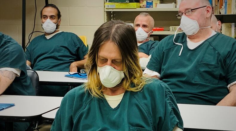 Corbet Justice, an inmate of the Greene County Adult Detention Center, reads over a copy of Dr. Seuss's "Do You Know How Lucky You Are?" during a workshop with nonprofit Story Chain.