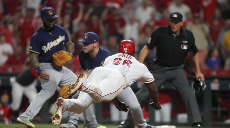 The Reds’ Yasiel Puig scores the winning run against the Brewers on Tuesday, July 2, 2019, at Great American Ball Park in Cincinnati. David Jablonski/Staff