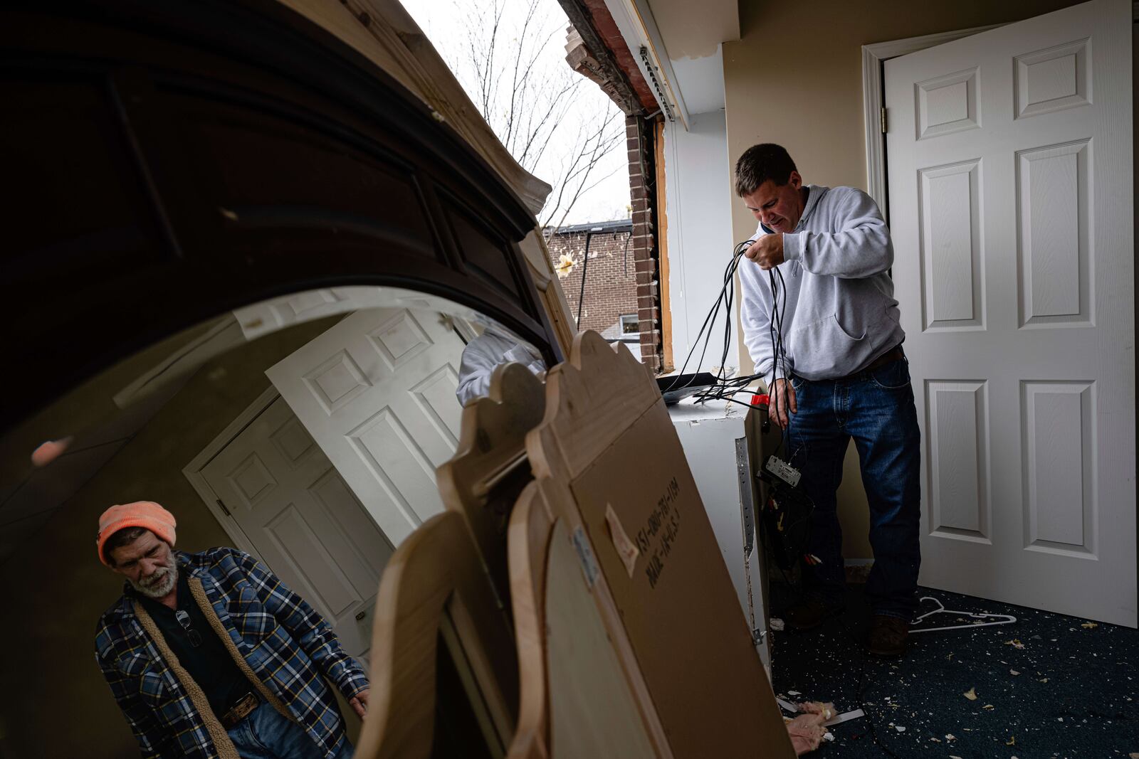 People remove items from a business damaged in the Triad Building, a business plaza, after severe weather passed through on Thursday, April 3, 2025, in Louisville, Ky. (AP Photo/Jon Cherry)