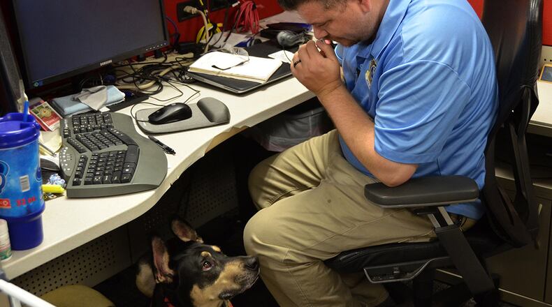 Ryan Kaono, a support agreement manager with the Air Force Installation and Mission Support Center, takes a moment to breath while his service dog Romeo assesses the situation. Romeo helps Kaono quickly recover from bouts of anxiety and night terrors related to enemy attacks while he was deployed to Saudi Arabia and Iraq. (U.S. Air Force photo/Armando Perez)