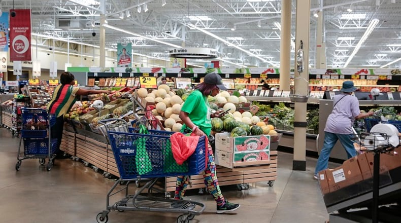 Shipt shopper Gina Moorman of Detroit, center, scans through her shopping list as she walks through the produce section at Meijer, Thursday, June 22, 2017 in Detroit. (Junfu Han/Detroit Free Press/TNS)