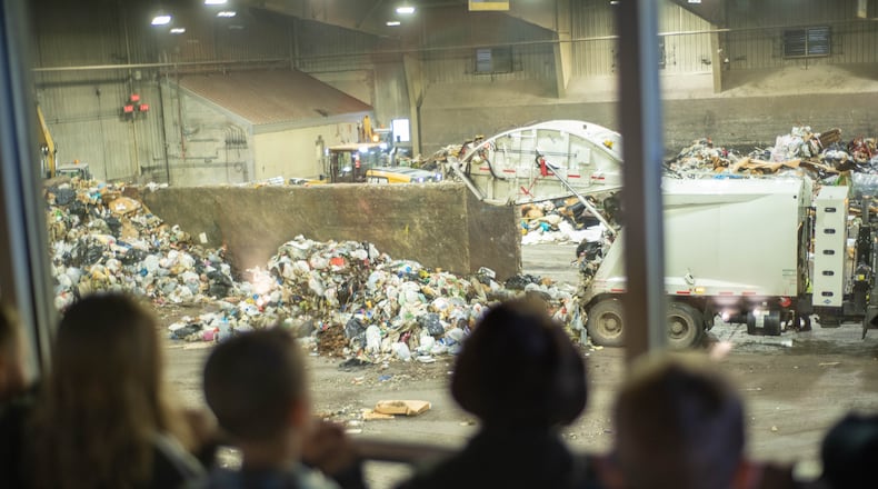 Children watch as trash is processed on the solid waste tipping floor at the Montgomery County Solid Waste facility in Moraine.