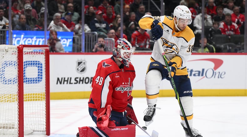 Washington Capitals goaltender Logan Thompson (48) and Nashville Predators left wing Michael Bunting (58) battle for the puck during the second period of an NHL hockey game, Thursday, Feb. 5, 2026, in Washington. (AP Photo/Nick Wass)