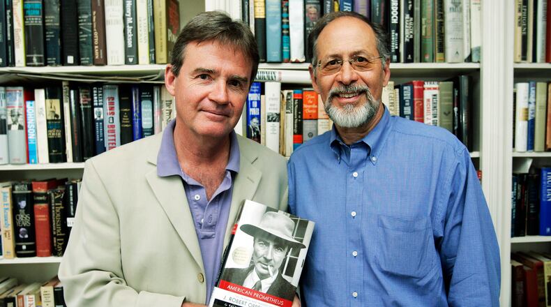 FILE - In this April 17, 2006, file photo, co-authors Kai Bird, left, and Martin J. Sherwin, right, hold a copy of the book they wrote "American Prometheus: The Triumph and Tragedy of J. Robert Oppenheimer," in Washington. Sherwin, a leading scholar of atomic weapons who in “A World Destroyed” challenged support for the U.S. bombing of Japan and spent more than two decades researching the pioneering physicist J. Robert Oppenheimer for the Pulitzer Prize-winning “American Prometheus,” has died at age 84. Sherwin died Wednesday, Oct. 6, 2021, at his home in Washington, D.C., according to his friend Andrew Hartman, a professor of history at Illinois State University.  (AP Photo/Manuel Balce Ceneta, File)