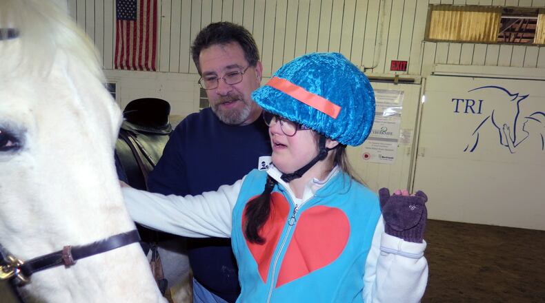Dave Ball helps his student Kara get to know a horse. Ball devotes about 200 hours per year to volunteering for TRI and helping disabled kids through horse therapy. CONTRIBUTED