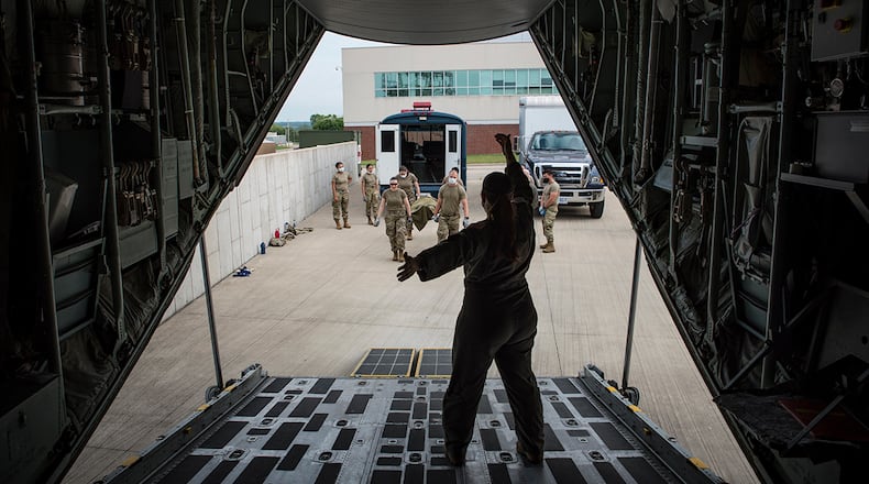 Capt. Alicia Houston, U.S. Air Force School of Aerospace Medicine flight nurse instructor, directs a team of medics, which just unloaded a patient manikin from an ambulance bus, up the ramp into a C-130 during deployment training Aug. 12. U.S. AIR FORCE PHOTO/RICHARD ELDRIDGE