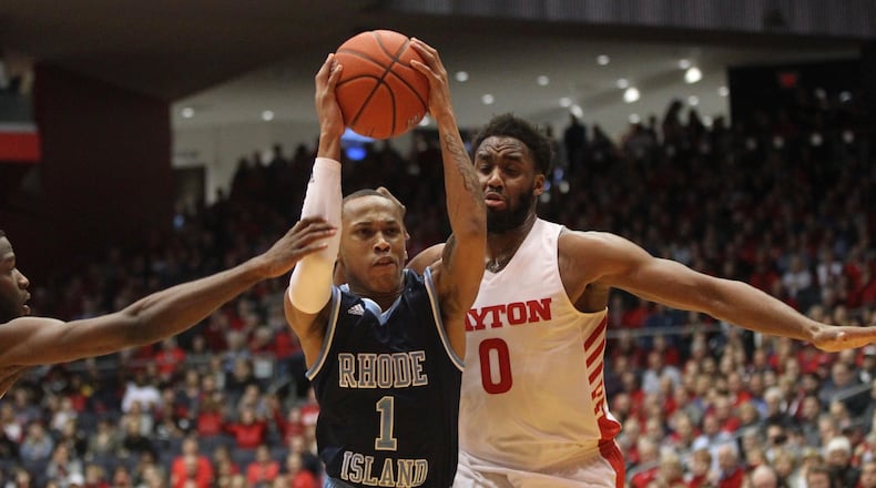 Rhode Island's Fatts Russell drives to the basket between Dayton's Jalen Crutcher, left, and Josh Cunningham in the first half on Friday, March 1, 2019, at UD Arena.