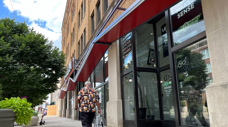 A pedestrian walks by Downtown Dayton Optical on Wednesday. CORNELIUS FROLIK / STAFF