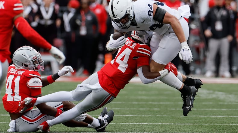 Ohio State defensive back Jermaine Mathews, left, tackles Penn State tight end Theo Johnson during the second half of an NCAA college football game Saturday, Oct. 21, 2023, in Columbus, Ohio. (AP Photo/Jay LaPrete)