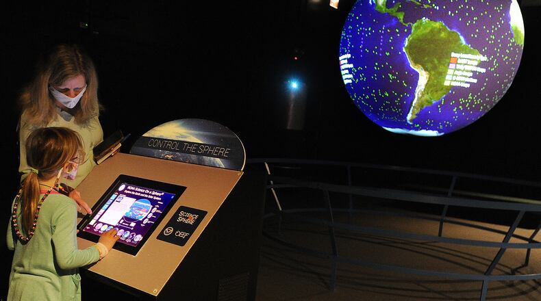 Tracey Tomme, President and CEO, Boonshoft Museum of Discovery, helps Piper Fles, age 6, at the Control The Sphere, exhibit at the museum, Monday April 5, 2021. MARSHALL GORBY\STAFF