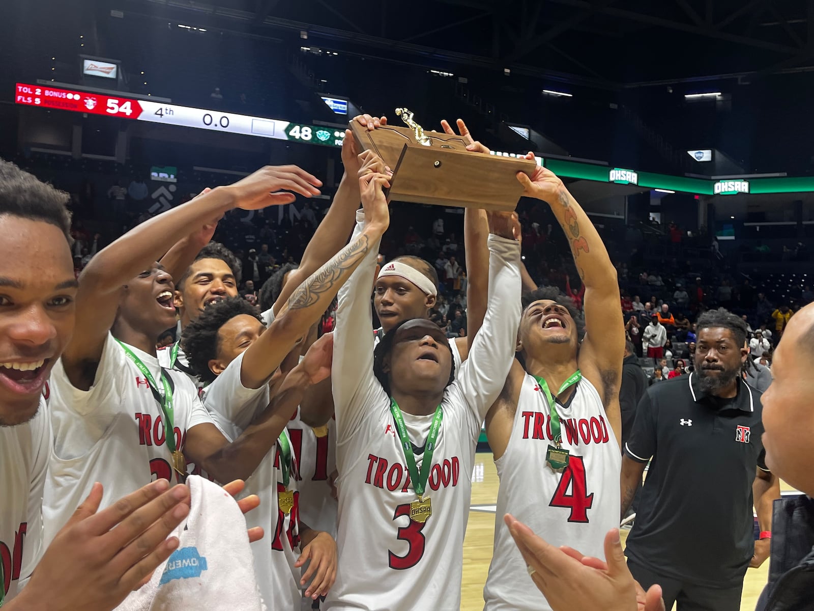 The Trotwood-Madison High School boys basketball team lifts the trophy after beating Hamilton Badin in the Division III, Region 12 championship game  on Saturday, March 14, 2026 at Xavier University's Cintas Center. GEOFF NEVILLE / CONTRIBUTED PHOTO