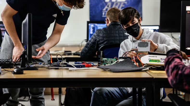 Kettering Fairmont seniors from left, Christian Carnes and Dylan Damiano test hardware in senior information technology class at the school Wednesday Dec. 1, 2021. A state committee on computer science aims to make Ohio a national leader in computer science education. JIM NOELKER/STAFF