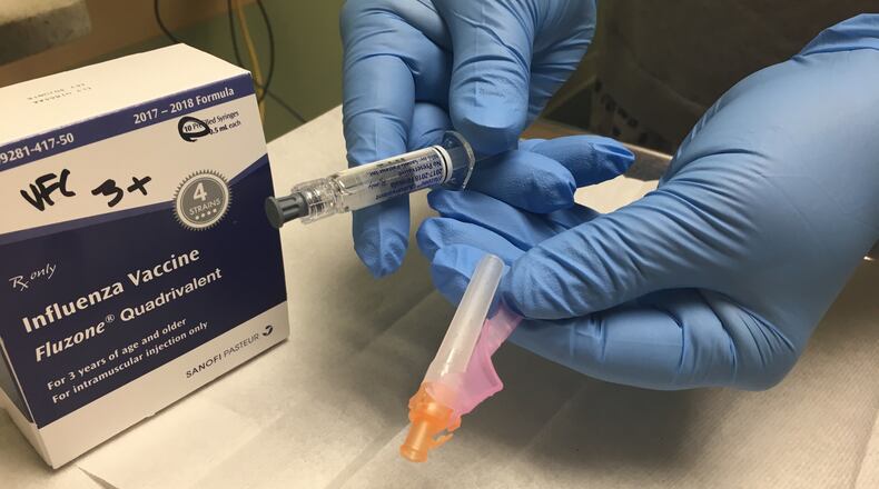 FILE PHOTO: An official with Public Health - Dayton & Montgomery County holds a flu vaccine. KAITLIN SCHROEDER/STAFF