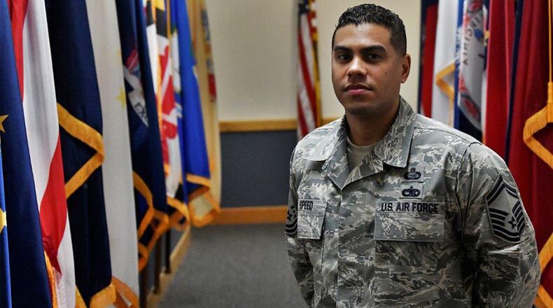 Senior Master Sgt. Calvin Speed, the Air Force Materiel Command training manager, stands next to the flags that he protects at AFMC headquarters, Wright-Patterson Air Force Base. (U.S. Air Force photo/Darrius A. Parker)