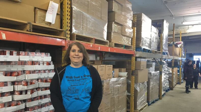 Nicole Adkins stands inside With God s Grace s warehouse on Springfield Street in east Dayton. CORNELIUS FROLIK / STAFF