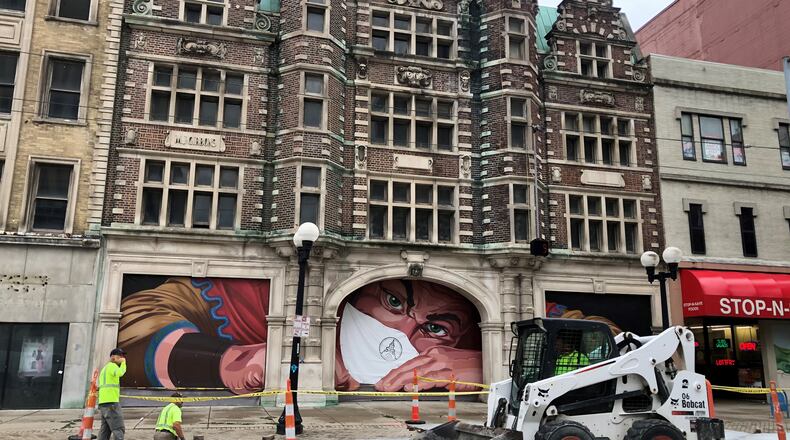 Crews on Friday work along East Third Street in front of the Dayton Arcade. CORNELIUS FROLIK / STAFF