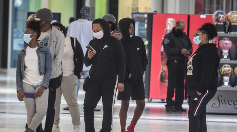 Around 300 people went shopping Tuesday morning at the Dayton Mall. The doors opened at 11 a.m. for 50 people waiting at the doors. About half the stores appeared to be open and about half the shoppers in the mall were wearing masks. JIM NOELKER/STAFF