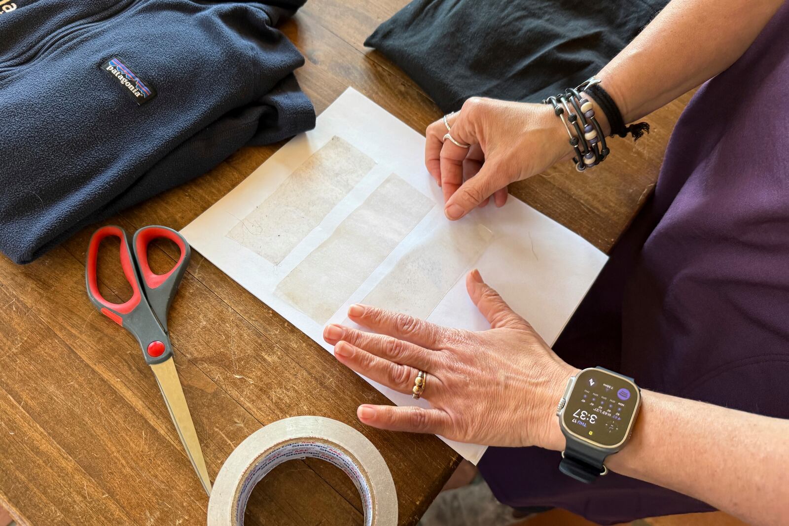 Rachael Z. Miller, founder of the Vermont-based Rozalia Project for a Clean Ocean, conducts a tape test on various clothing items to compare how much each material sheds microfibers on Thursday, April 17, 2025, in Granville, Vt. (AP Photo/Amanda Swinhart)