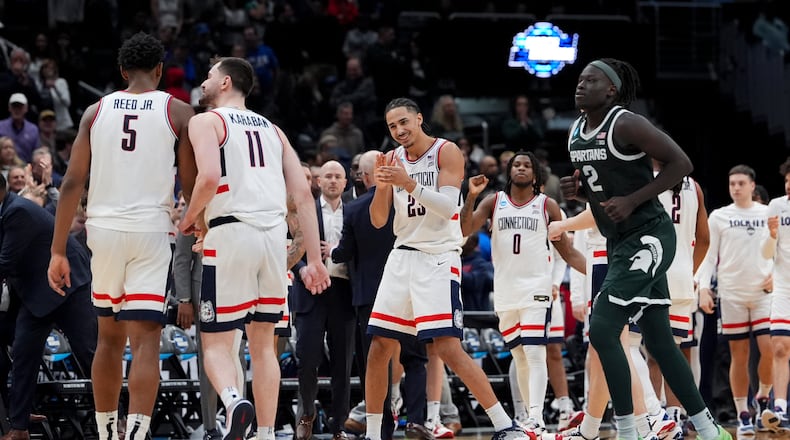UConn forward Jayden Ross (23) celebrates with forward Tarris Reed Jr. (5) and forward Alex Karaban (11) against Michigan State during the second half in the Sweet 16 of the NCAA college basketball tournament, Saturday, March 28, 2026, in Washington. (AP Photo/Stephanie Scarbrough)