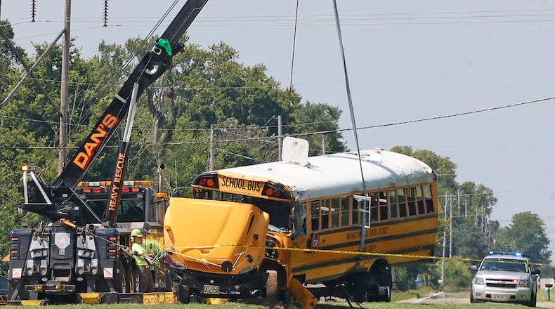 A Northwestern School District bus is uprighted by a crane after it was involved in a crash with another vehicle and rolled over in Lawrenceville, Ohio, Tuesday, Aug. 22, 2023. (Bill Lackey/The Springfield News-Sun)