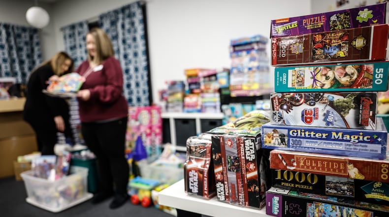 Tiffany Doakes and MyKaelah Mercer look over toys that will be given to children in need. Christmas Smiles has served more than 1,300 children since it was founded in 2009. JIM NOELKER/STAFF