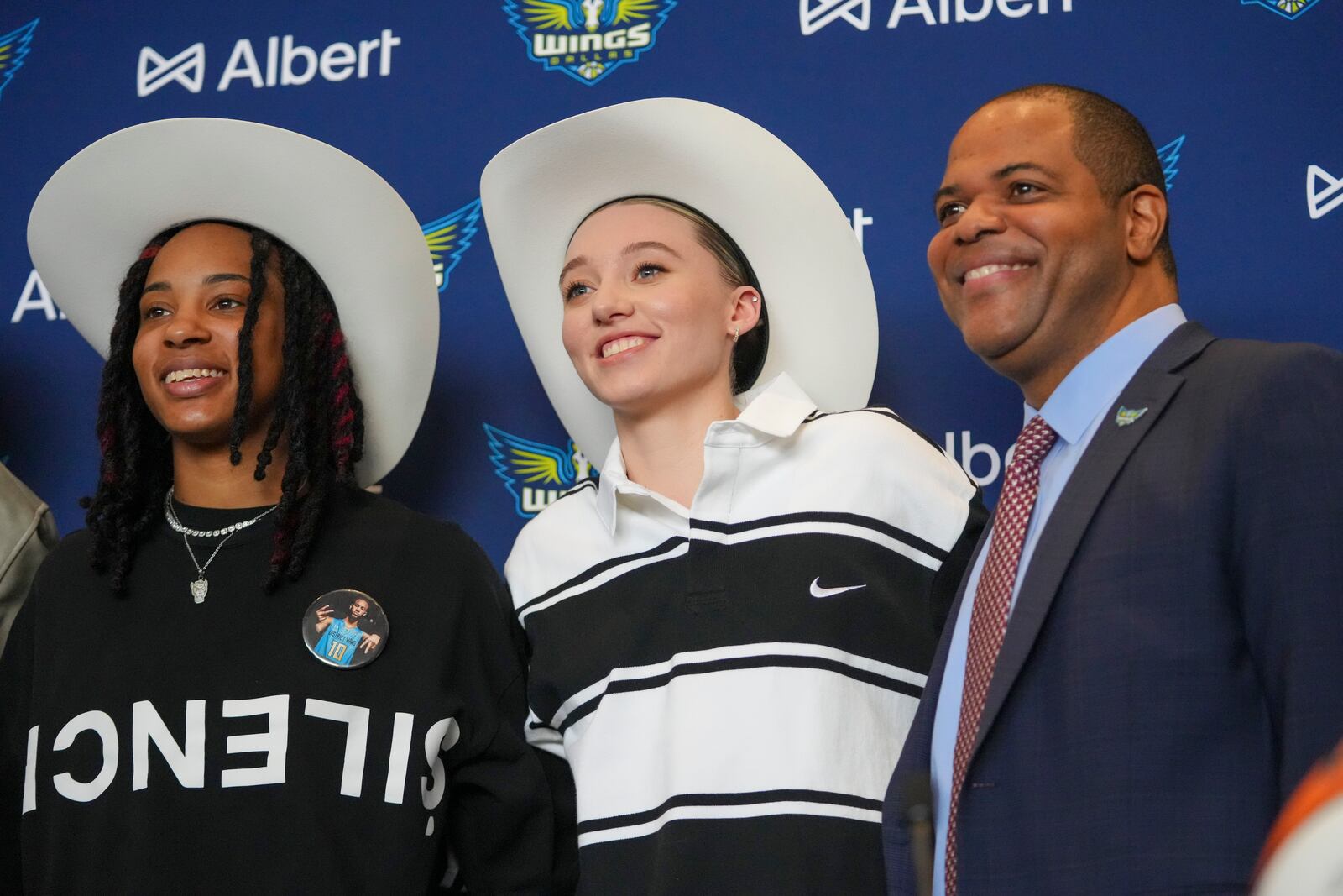 Dallas Wings' Paige Bueckers, center, selected No. 1 overall in the WNBA basketball draft, and Aziaha James, selected No. 12 overall, sport a cowboy hats gifted to them while posing for photographs with Dallas Mayor Eric Johnson during an introductory press conference Wednesday, April 23, 2025, in Dallas. (AP Photo/Julio Cortez)