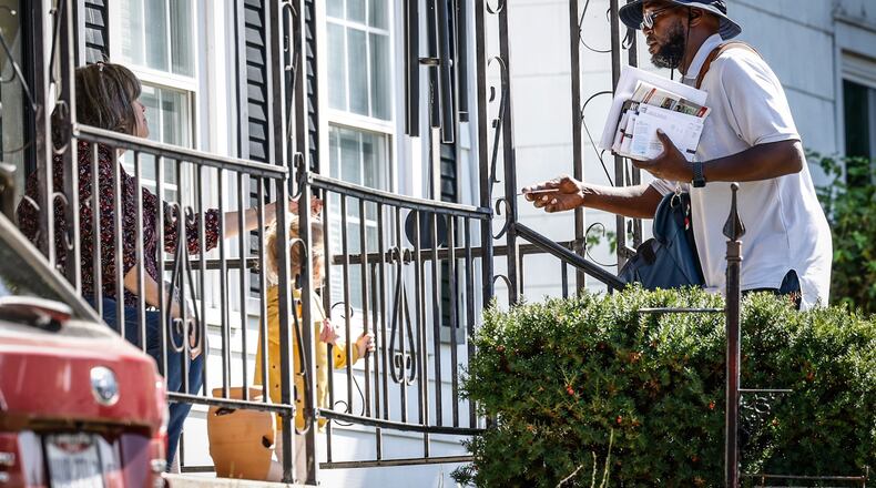 A mail carrier delivers mail to a Dayton eastside resident October 5, 2022. JIM NOELKER/STAFF