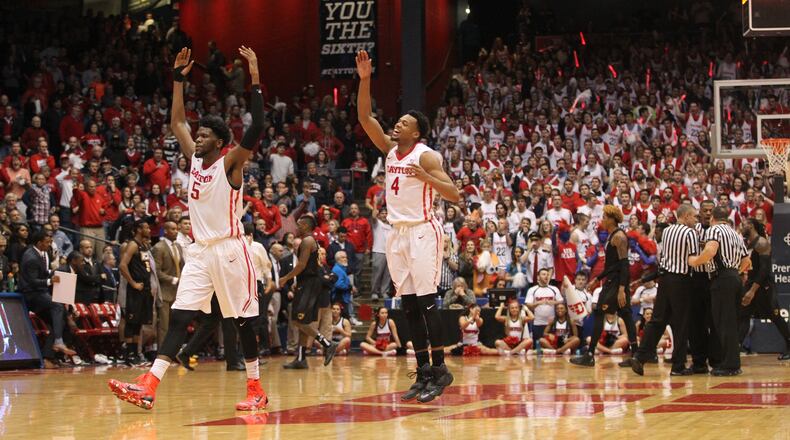 Dayton’s Steve McElvene, left, and Charles Cooke celebrate a play during a game against VCU on March 5, 2016, at UD Arena. David Jablonski/Staff