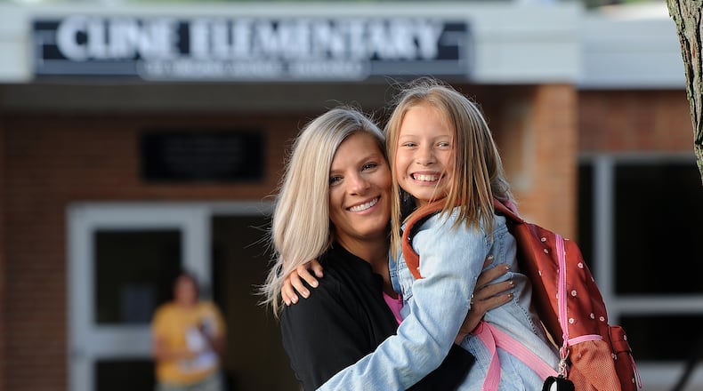 Bekah Stull hugs her daughter Rylee, age 9, goodbye on the first day of school Wednesday, Aug. 16, 2023 at Cline Elementary in Centerville. MARSHALL GORBY\STAFF