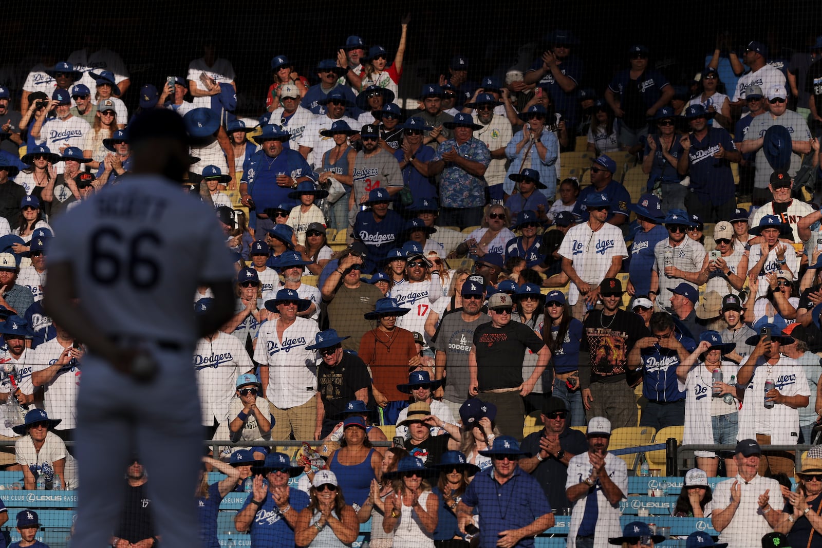 FILE - Fans cheer as Los Angeles Dodgers pitcher Tanner Scott prepares to throw during the ninth inning of a baseball game against the San Francisco Giants in Los Angeles, Saturday, June 14, 2025. (AP Photo/Jessie Alcheh, File)