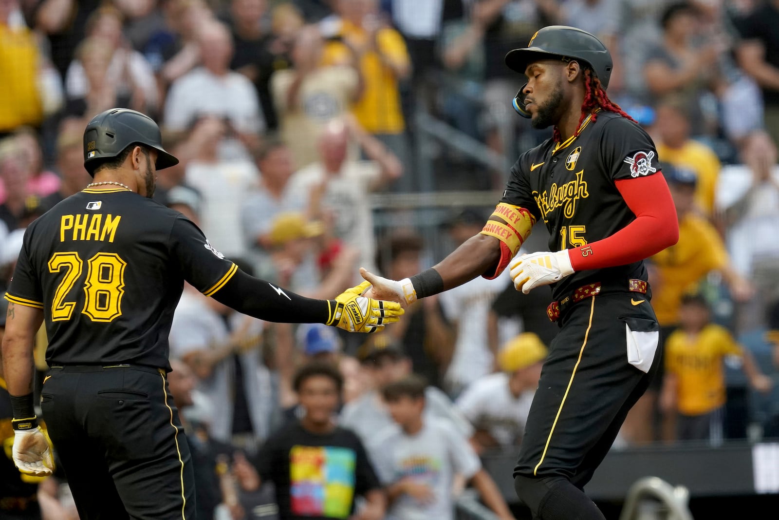 Pittsburgh Pirates' Oneil Cruz, right, is greeted by Tommy Pham, left, after hitting a two-run home run during the second inning of a baseball game against the Arizona Diamondbacks Saturday, July 26, 2025, in Pittsburgh. (AP Photo/Matt Freed)