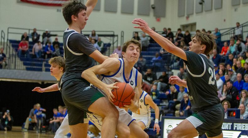 Russia's Benjamin York gets fouled on his way to the basket by Troy Christian's Frank Rupnik while Alex Free closes from the other side during Tuesday night's Division IV region semifinal at Trent Arena. CONTRIBUTED/Jeff Gilbert