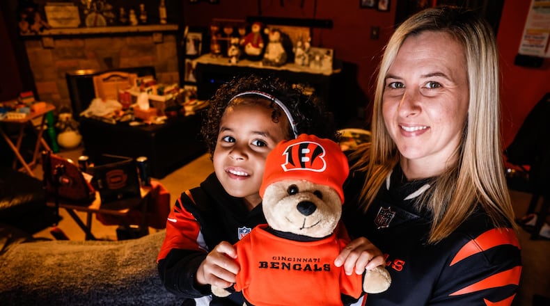 Astrid Whitfield and her daughter Aubriana show off their Cincinnati Bengals fan memorabilia. Whitfield has been a fan since she was 12 years old and followed the team while serving in Korea and Iraq during her years with the U.S. Army. JIM NOELKER/STAFF