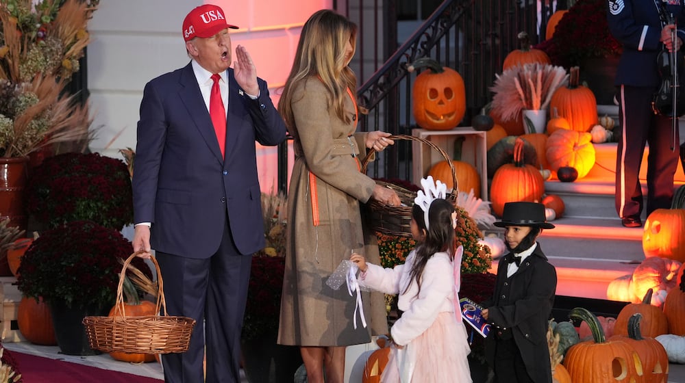 President Donald Trump, from left, and first lady Melania Trump hand candy to children dressed the Tooth Fairy and Abraham Lincoln during a Halloween event on the South Lawn of the White House, Thursday, Oct. 30, 2025, in Washington. (AP Photo/Jacquelyn Martin)