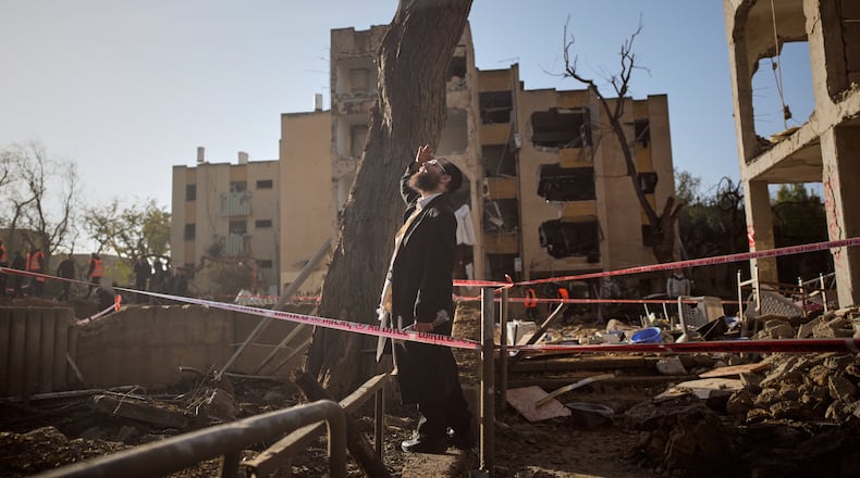 A man looks at residential buildings damaged by an Iranian missile strike in Arad, southern Israel, Sunday, March 22, 2026. (AP Photo/Ohad Zwigenberg)
